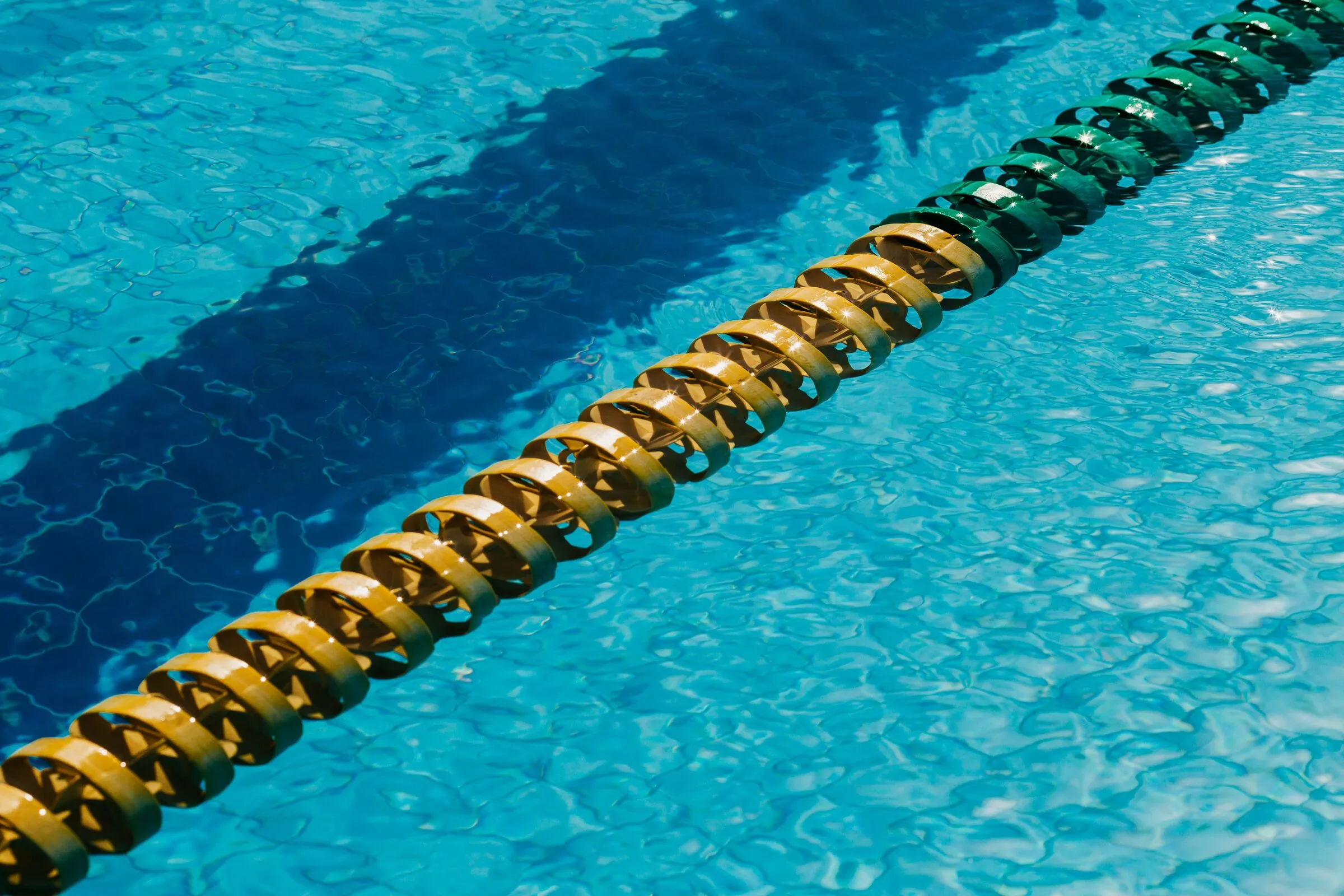 Gelbe Schwimmleine trennt zwei Bahnen im klaren Wasser
